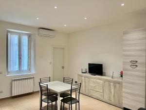 a dining room with a table and chairs and a television at Alloggio Nina 2 in Biella