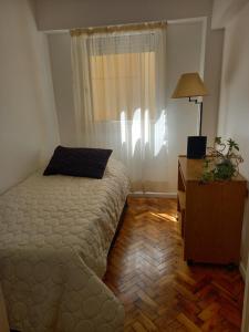 um quarto com uma cama, uma cómoda e uma janela em Centro em Buenos Aires
