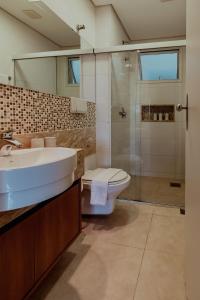 a bathroom with a sink and a toilet and a shower at Bloom Guesthouse in Holambra