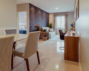 a dining room and living room with a table and chairs at Bloom Guesthouse in Holambra