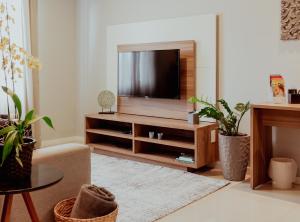 uma sala de estar com televisão num centro de entretenimento em Bloom Guesthouse em Holambra