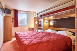 Habitación de hotel con cama roja y literas en Premiere Classe Le Mans Ouest Universite, en Le Mans