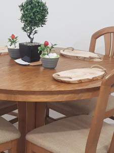 ein Holztisch mit Tellern und Topfpflanzen darauf in der Unterkunft City Diamond Apartment in Skopje + 18 Fotos