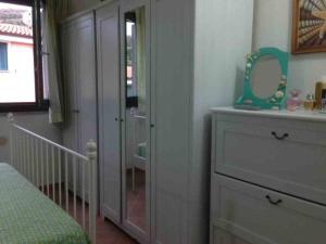 1 dormitorio con tocador y espejo junto a una puerta en Holiday in Sardinia, en Santa María