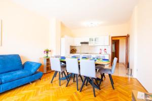 a living room with a table and chairs and a blue couch at Apartments Facini in Košljun +20 photos