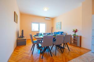 a dining room with a table and chairs at Apartments Facini in Košljun