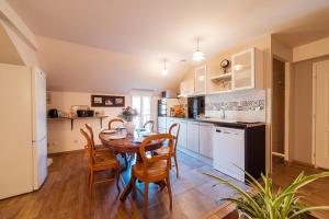 een keuken met een tafel en stoelen in een kamer bij Logements calmes avec piscine, jardin et parking in Buchères