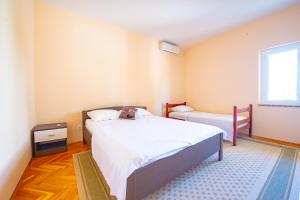 a bedroom with a large bed and a window at Apartments Facini in Košljun