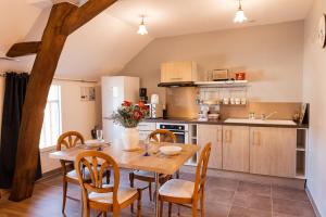 een keuken met een houten eettafel en stoelen bij Logements calmes avec piscine, jardin et parking in Buchères