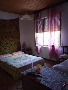 a bedroom with two beds and a window at Affittacamere Cooperativa Olistica in Mamoiada