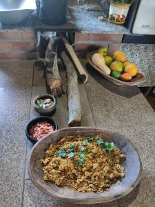 a bowl of food on a counter with bowls of fruit at Recanto das Aves in Botumirim
