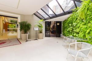 a lobby with plants and a glass table and chairs at 360 Cerqueira César in Sao Paulo