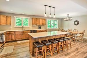 a kitchen with a large island with bar stools at Cabin with Dock and Porch Across from Balsam Lake in Balsam Lake