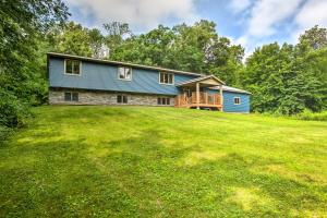 a blue house on a hill with a large yard at Cabin with Dock and Porch Across from Balsam Lake in Balsam Lake