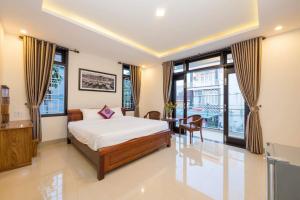 1 dormitorio con 1 cama, mesa y sillas en Papaya Garden Homestay en Hoi An