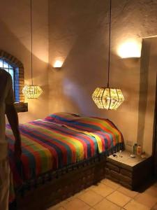 a bedroom with a bed with a colorful striped blanket at Casa Rustica Reserva Biosfera Tehuacan Cuicatlan 