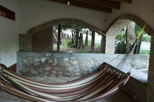 a hammock in a room with a stone wall at Casa Rustica Reserva Biosfera Tehuacan Cuicatlan 