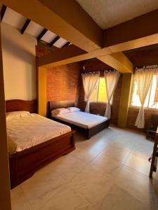 1 dormitorio con 1 cama grande y 2 ventanas en Casa de verano, en Santa Fe de Antioquia