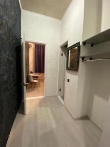 - un couloir avec une porte et une table dans une chambre dans l'établissement Міні готель на Костюринському, à Kharkov