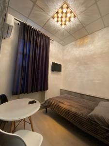um quarto com uma cama e uma mesa e uma mesa e cadeiras em Міні готель на Костюринському em Kharkov