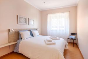 sypialnia z dużym białym łóżkiem z 2 ręcznikami w obiekcie Charming 120m² in Historic Center w mieście Lamego