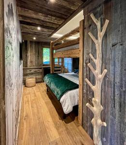 een slaapkamer met een bed in een blokhut bij Chalet de luxe sur les pistes - 5 chambres in Combloux