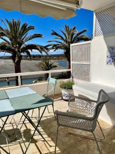 a table and chairs on a balcony with palm trees at Sotogrande Paseo del Rio in Sotogrande