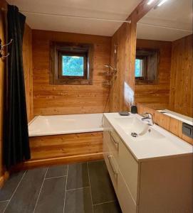 a bathroom with a bath tub and a sink at Chalet de luxe sur les pistes - 5 chambres in Combloux