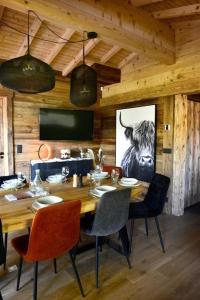uma sala de jantar em madeira com uma mesa e cadeiras em Chalet de luxe sur les pistes - 5 chambres em Combloux
