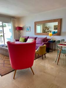 a living room with a red couch and a mirror at Sotogrande Paseo del Rio in Sotogrande