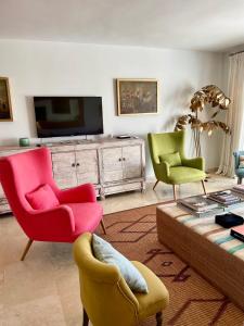 a living room with two chairs and a tv at Sotogrande Paseo del Rio in Sotogrande