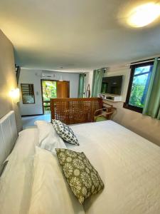 a bedroom with a large bed with two pillows on it at Pousada Palmeiras in Bombinhas