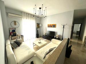 salon z białą kanapą i żyrandolem w obiekcie Sambatra home w mieście Palermo