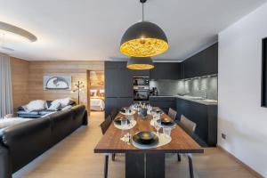 een keuken en een woonkamer met een tafel en een bank bij La P'tite Grange - Apt 302 - BO Immobilier in Châtel