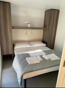 a bedroom with a bed with two towels on it at Mobilna kućica Val in Šimuni