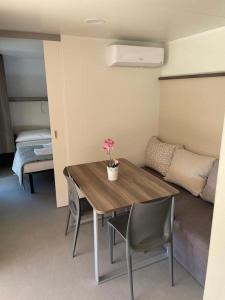 a room with a table and chairs and a bedroom at Mobilna kućica Val in Šimuni +22 photos