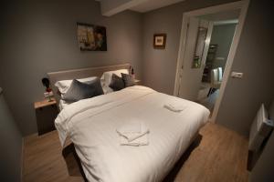 een slaapkamer met een groot bed met witte lakens bij B en B Volendam in Volendam