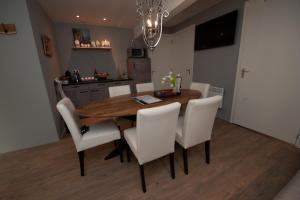 a dining room with a wooden table and white chairs at B en B Volendam in Volendam