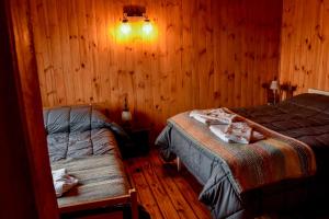 um quarto com 2 camas num quarto com paredes de madeira em Cabaña El Maqui em San Martín de los Andes