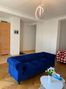 Sofá azul en la sala de estar con mesa en City appartement, en Lausana