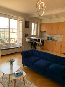 a living room with a blue couch and a kitchen at City appartement in Lausanne