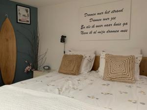 a bedroom with a bed with a sign on the wall at Appartement 't Zomerhuis in Zandvoort