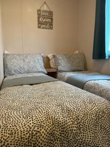 a room with two beds in a room at Beautiful 3 bedroom caravan with hot tub - Tattershall Lakes in Tattershall