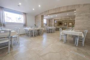 une salle à manger avec des tables et des chaises blanches dans l'établissement Agriturismo Bellofatto, à Torella deʼ Lombardi