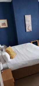 1 dormitorio con 1 cama con pared azul en Mersey View, Two Bedroom Apartment, Liverpool en Waterloo