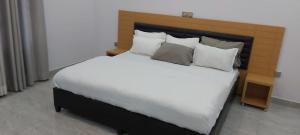 a bedroom with a large bed with white sheets and pillows at Easternhillshotels&Spa in Kigali