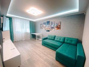 ein Wohnzimmer mit einer grünen Couch und einem Tisch in der Unterkunft Best location in City center in Chişinău + 2 Fotos