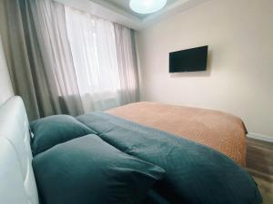 Schlafzimmer mit einem Bett und einem Flachbild-TV in der Unterkunft Best location in City center in Chişinău