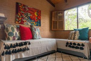 Habitación con sofá y almohadas coloridas. en Segredo dos Pireneus en Pirenópolis