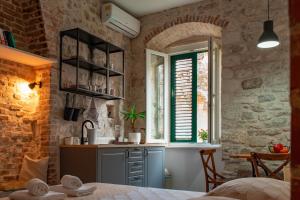 uma cozinha com um balcão, um lavatório e uma janela em Rooms and Apartments Djanovic em Split